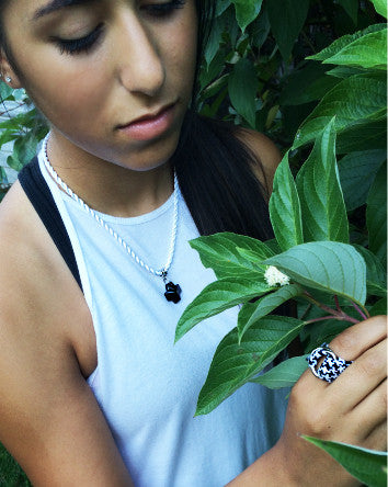 obsidian crystal cross contrasts with soft white twist cord