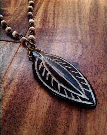 carved wood leaf on a tea-stained white bone-linked chain—feature