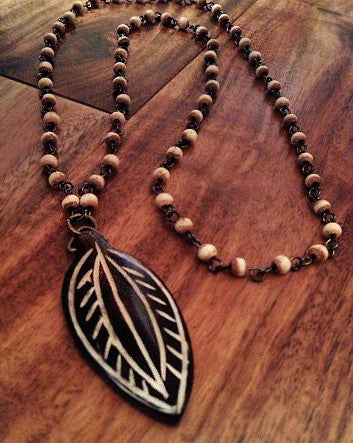 carved wood leaf on a tea-stained white bone-linked chain—feature