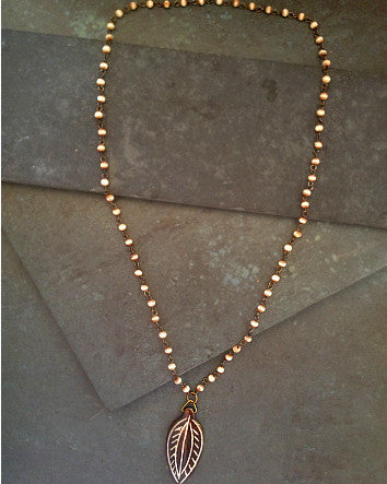 carved wood leaf on a tea-stained white bone-linked chain—feature